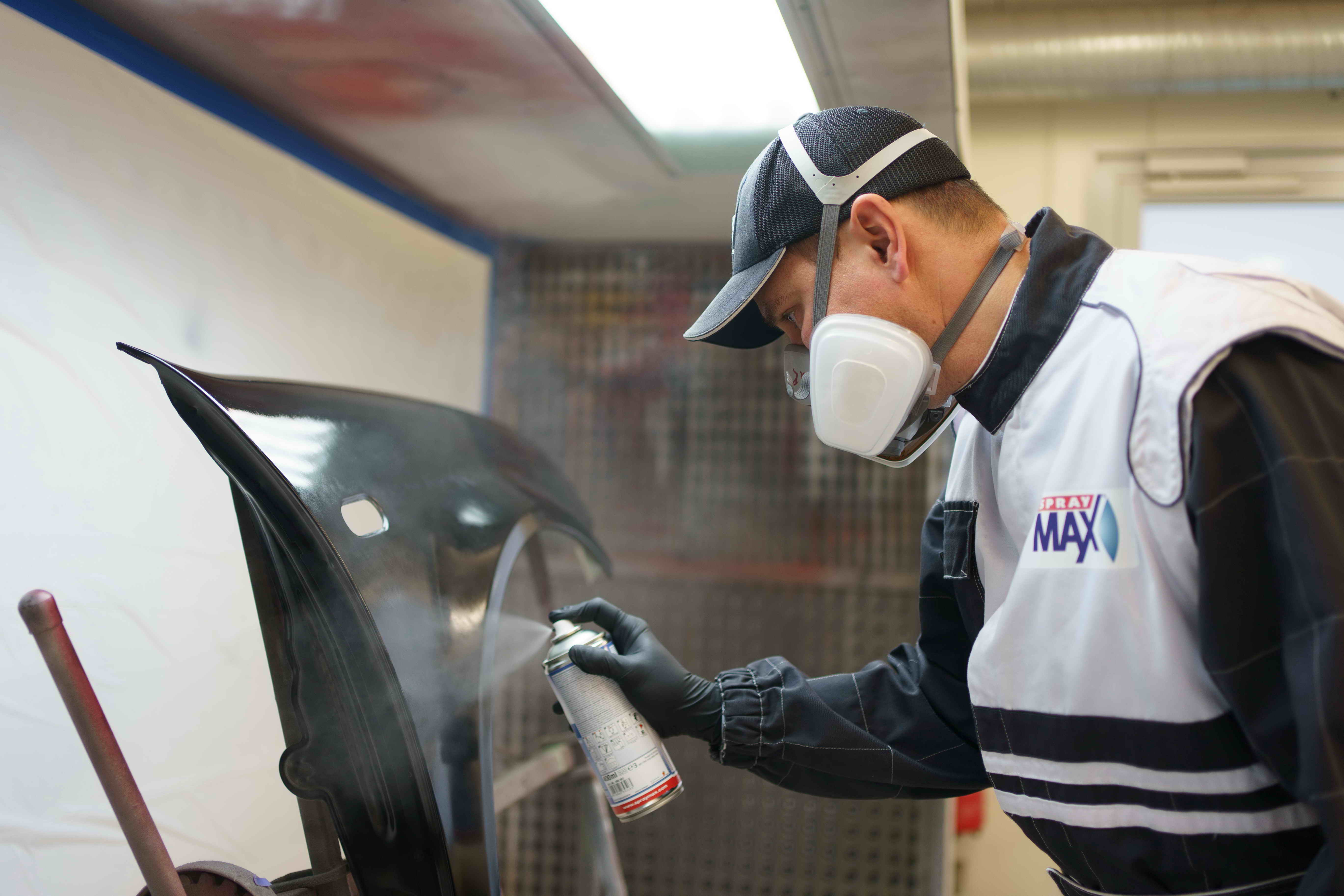 Anwendungstechniker lackiert Kotflügel